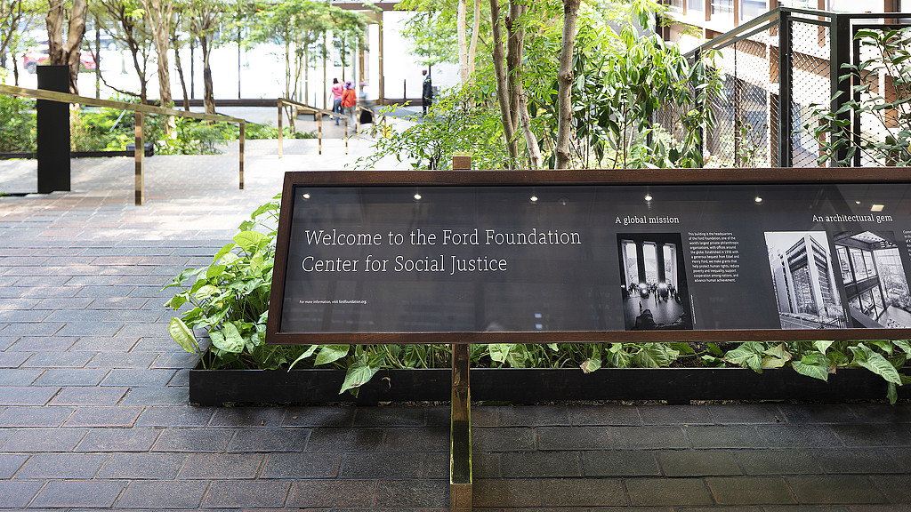 A sign on a brick walkway.